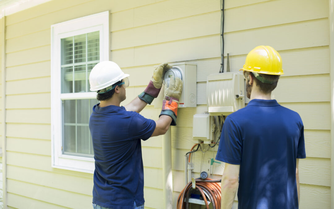 Electricians installing an EV charger on a residential home in Tampa, showcasing professional electrical services for homeowners.
