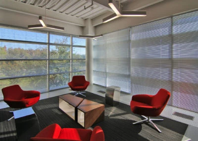 Modern lounge with four red chairs and a coffee table, showcasing Kazar’s Electric's inviting project aesthetics.