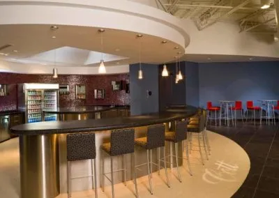 Modern bar counter with seating area in red and gray décor, showcasing Kazar's Electric installation elegance.