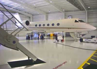 Sleek private jet in a well-lit hangar, showcasing Kazar's Electric precision and professionalism in aircraft maintenance.