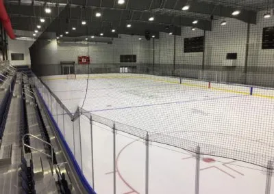 Hockey ice rink with calm atmosphere, goal posts, seating, and dasher boards, highlighting Kazar’s Electric's project focus.