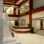 Modern interior of Kazar’s Electric office showcasing reception desk and staircase in a spacious, light-filled environment.