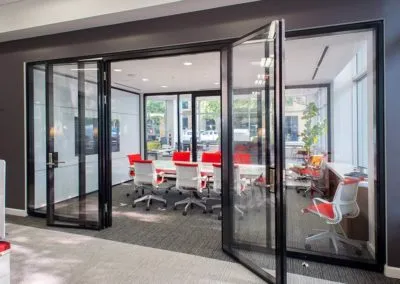 Modern conference room with glass walls and vibrant decor for Kazar’s Electric, Inc. electrical project collaboration.
