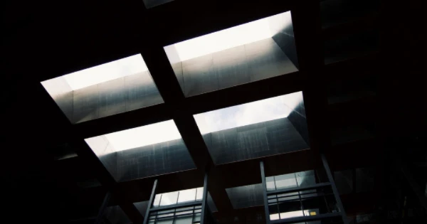 Industrial lighting installation with skylights allowing natural light, enhancing energy efficiency and visibility for commercial spaces.
