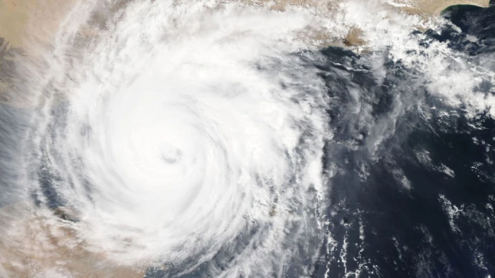 Hurricane swirling over ocean, emphasizing the need for emergency generators during hurricane season.