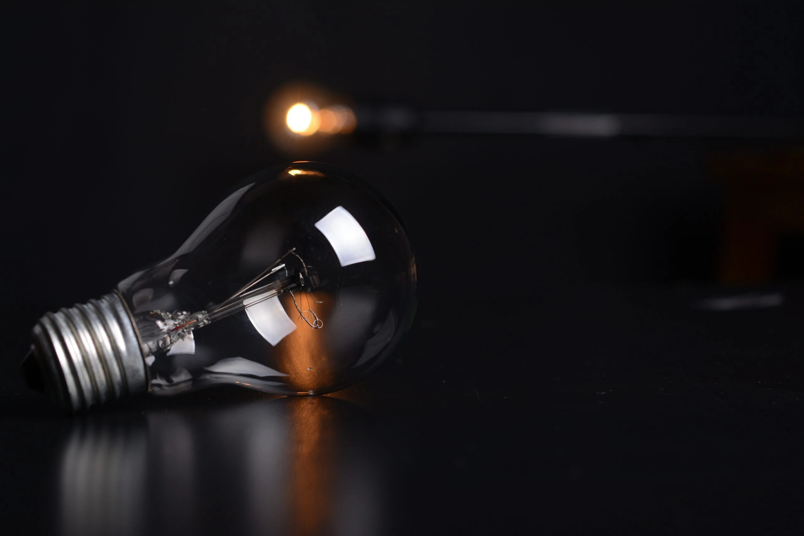 Light bulb on a dark surface, symbolizing energy efficiency and electric services, relevant to summer energy-saving tips by Kazar's Electric.